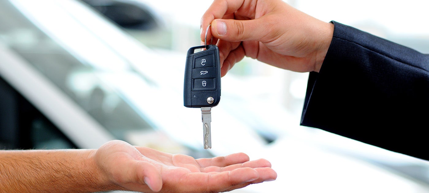 car salesman passing keys